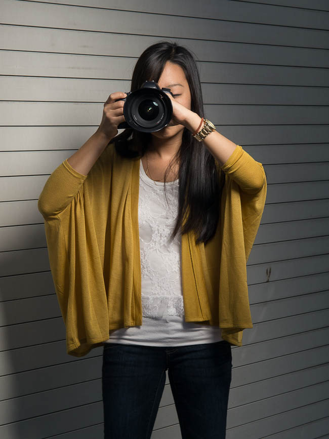 Incorrect camera holding technique showing elbows out to the sides creating an unstable platform for handheld shooting