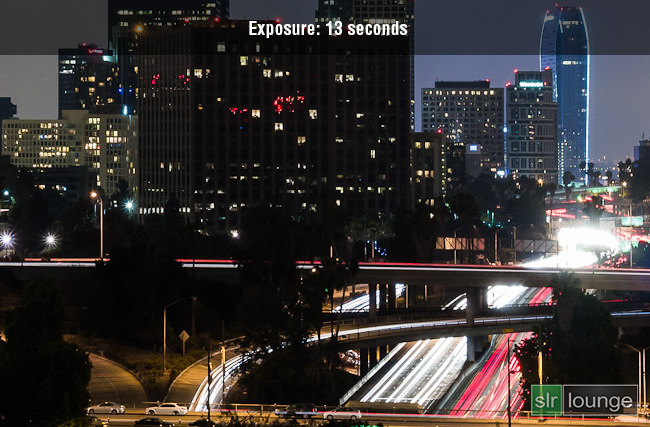 Long exposure photograph at 13 seconds showing car light trails against a dark urban background